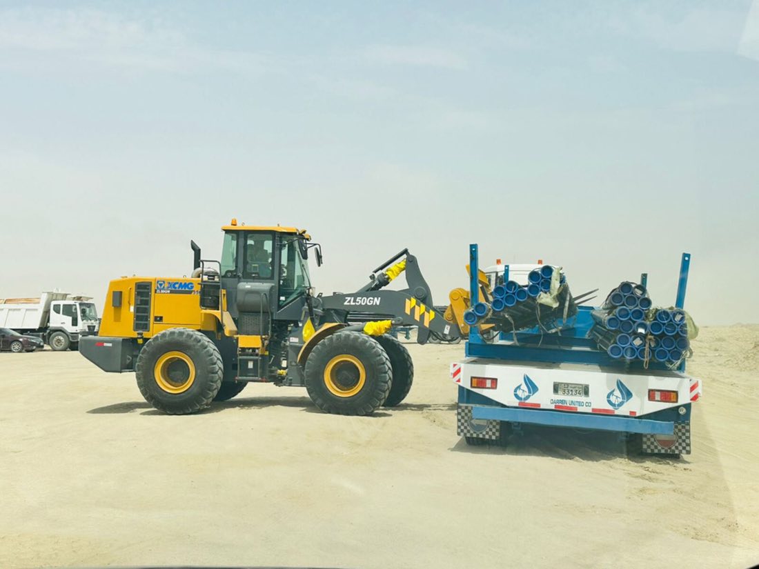 Wheel loader beside a Darren United flatbed trailer