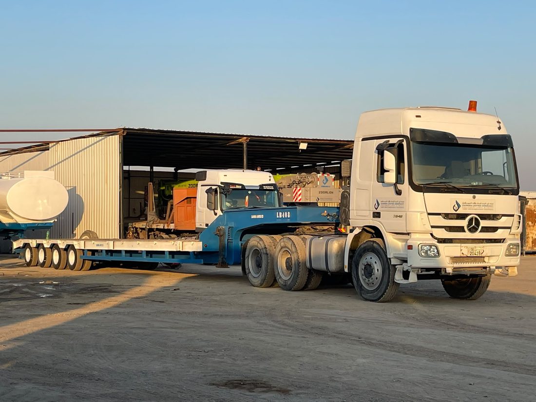 Low-bed trailer parked in the company yard at golden hour